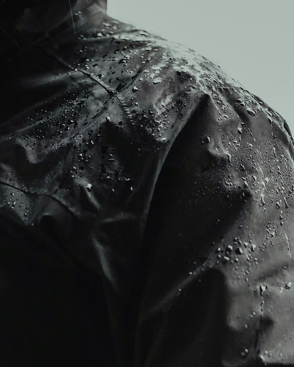 Rain beading on the shoulder of a coated jacket